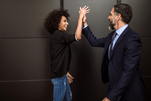 two businesspeople giving each other a high five