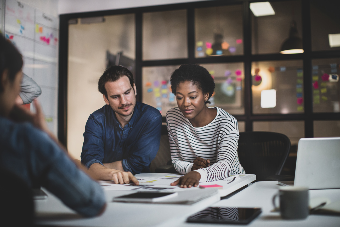 Mitarbeiterin und Mitarbeiter im Finance am Schreibtisch.