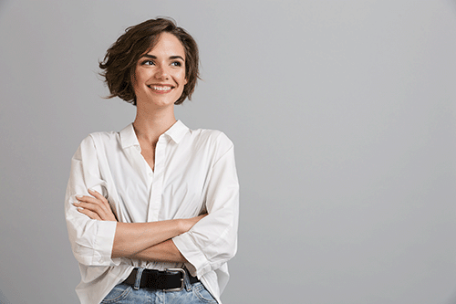 A business woman with crossed arms smiling and looking away