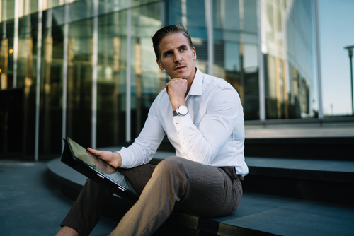 A businessman looking away and thinking about how to overcome imposter syndrome and embrace success