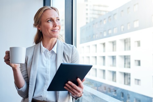 A businesswoman looking away and smiling while thinking about investing intentionally in organizational culture