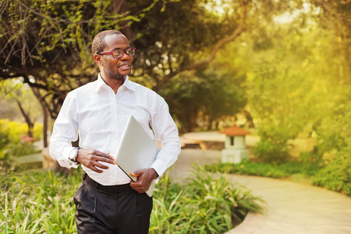 A businessman smiling and looking away while thinking about recruitment as a business strategy