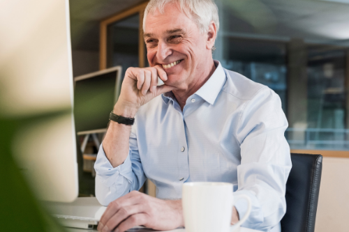 A smiling senior businessman in an office desk