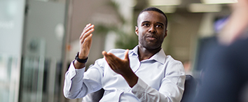 Picture of man sitting in office and gesticulate with hands