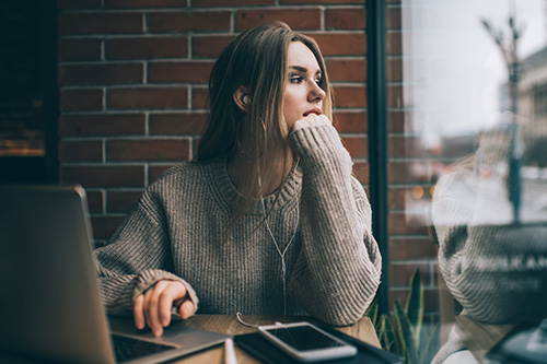 contemplative-female-freelancer-modern-earphones-listening