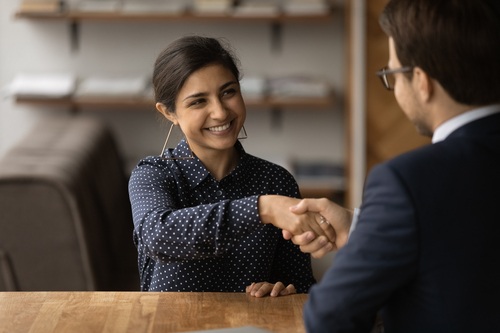 A businesswoman and businessman shaking hands