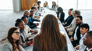 Empowered woman leading a diverse group meeting in a modern office setting