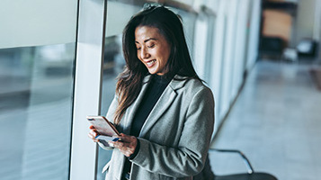 A businesswoman smiling and looking at a phone